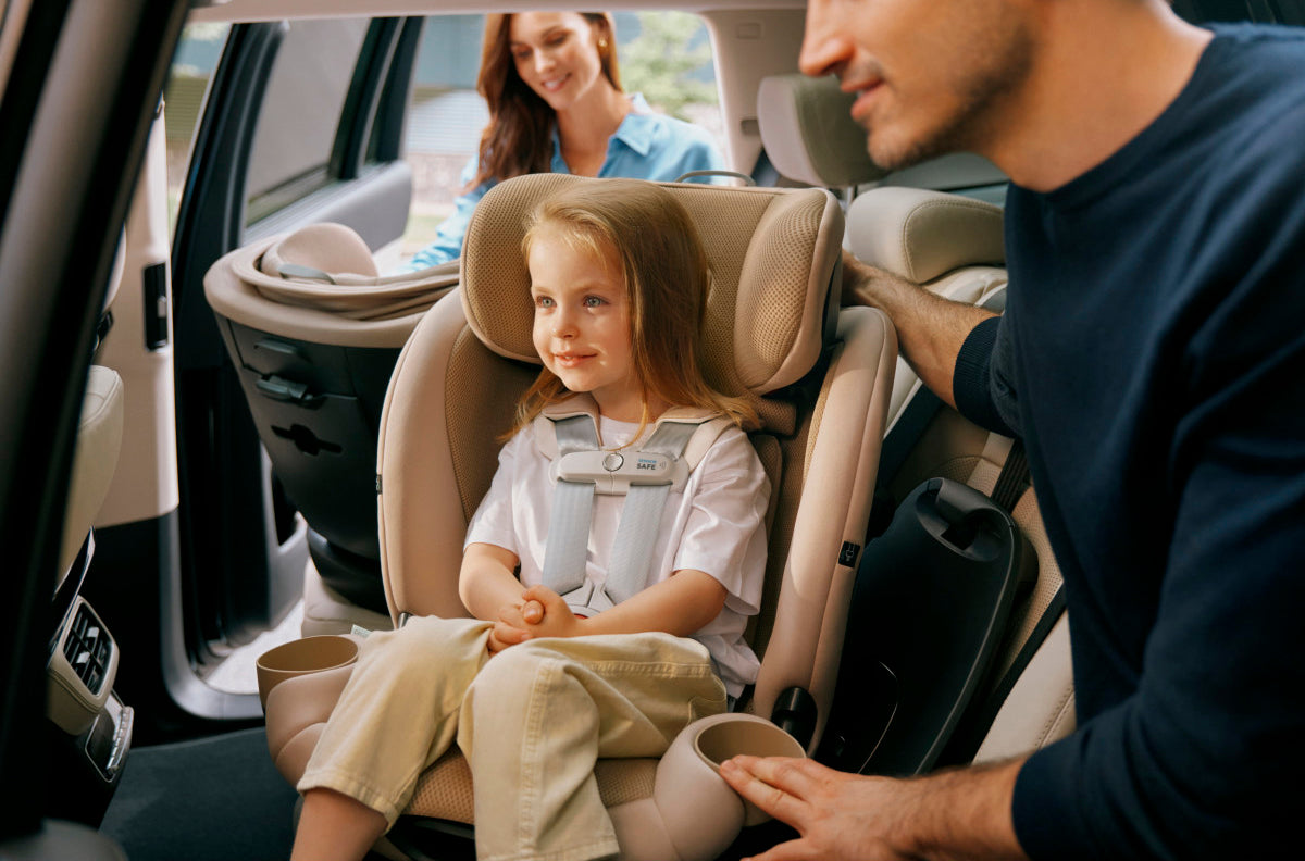a family placing their baby in a cybex car seat