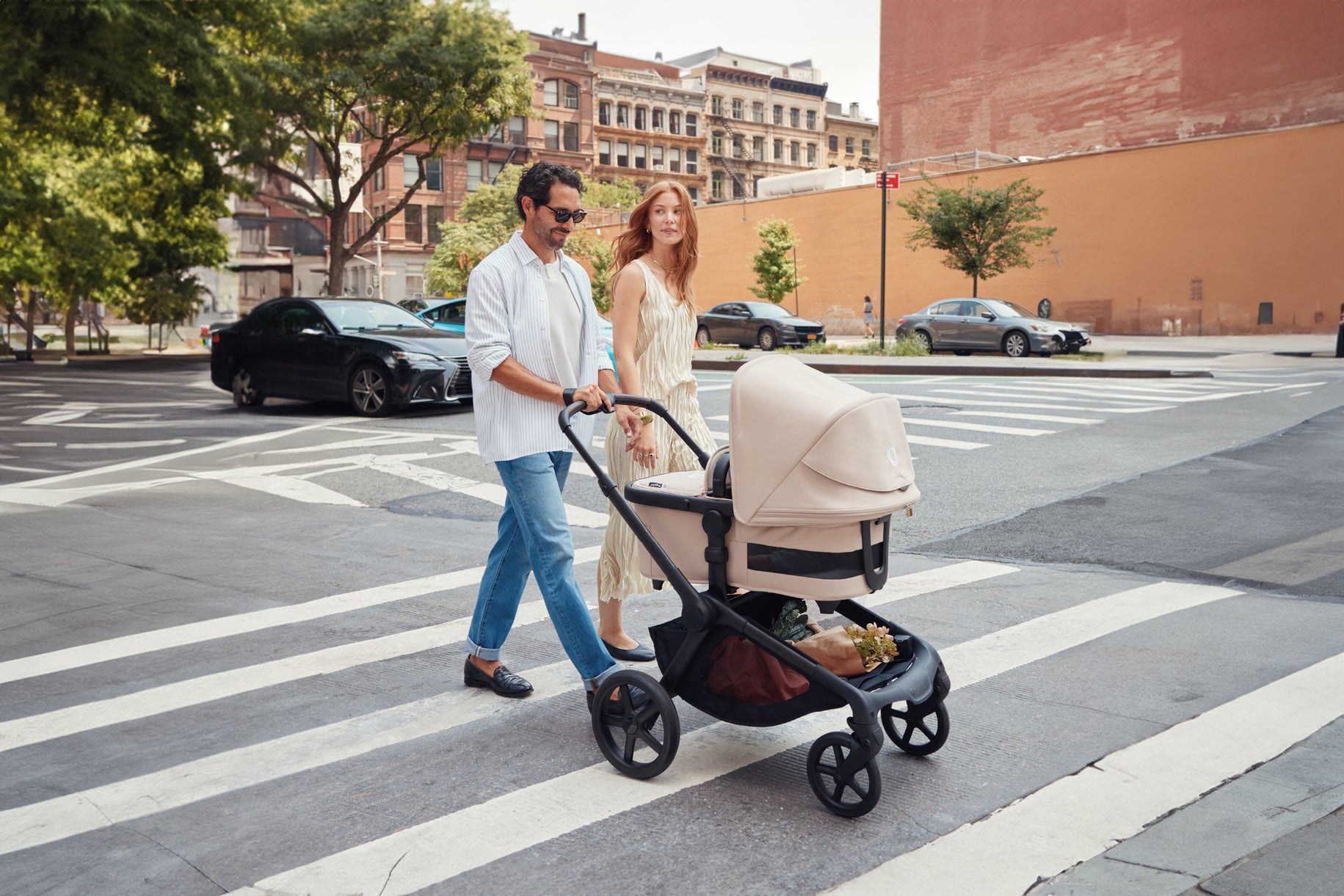 family pushing their bugaboo baby stroller across the street