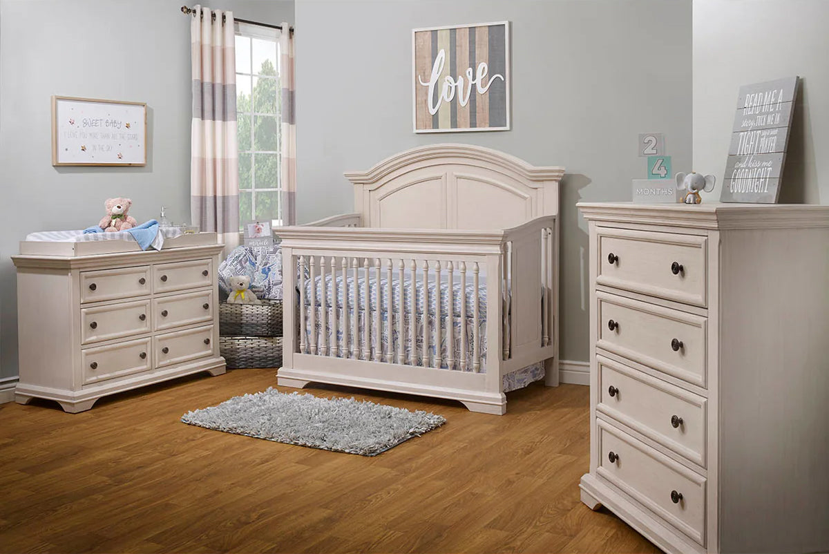 A charming baby room with the Fawn Baby Glacier convertible crib, dresser, and other essential furniture, providing a warm and inviting space for infants.